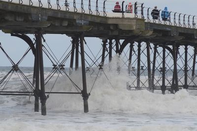 Low angle view of pier over sea against sky