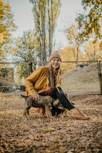 Woman standing by tree during autumn