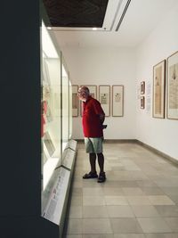 Rear view of a man walking on tiled floor