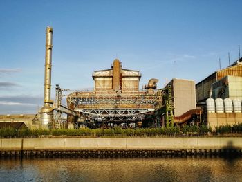 The reflection of the factory shortly after closing time on the surface of the river.