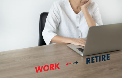 Midsection of woman using laptop on table