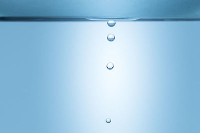 Close-up of water drop against blue background