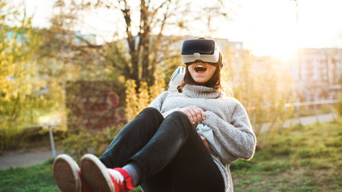 Couple using virtual reality simulator while standing at park