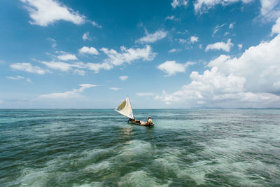 Sailboat in sea against sky
