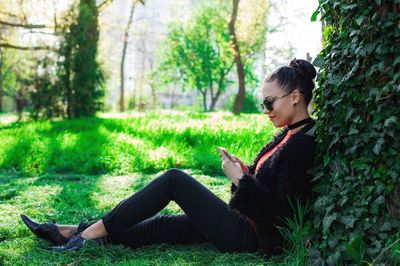 Rear view of woman sitting on grass