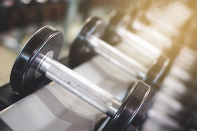 Close-up of dumbbells on rack in gym