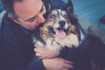 Close-up of man embracing dog in tent