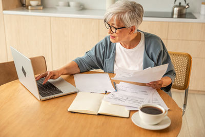 Man using laptop while sitting on table