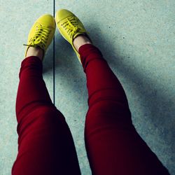 Low section of woman wearing shoes on floor