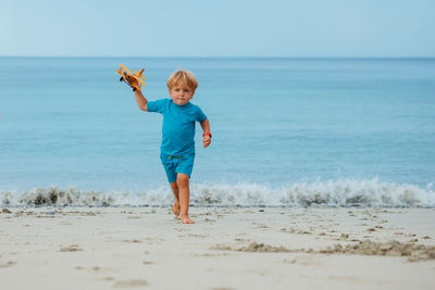 Full length of young woman standing at beach