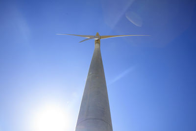 Low angle view of windmill against clear blue sky