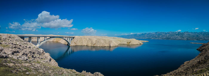 Panoramic shot of bridge over sea against blue sky