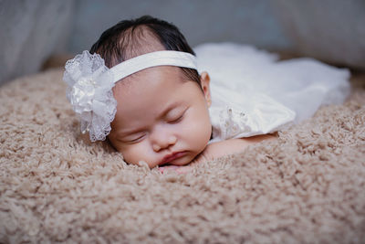 Cute baby girl sleeping on bed