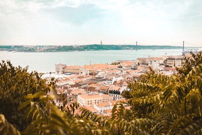 High angle view of townscape by sea against sky