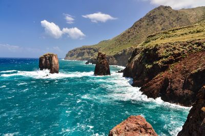 Scenic view of sea and mountains against sky