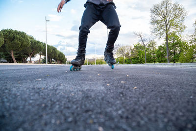 Low section of man roller skating on road