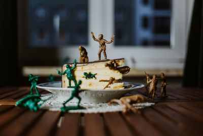 Army of toy soldiers fighting on the top of a piece of cake about having a dessert or not - close up