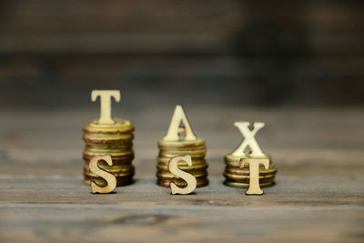 Close-up of stack coins with alphabets on table