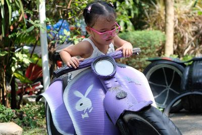 Cute girl sitting on toy motorcycle