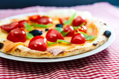 Close-up of pizza in plate on tablecloth