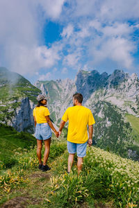 Rear view of people and mountains against sky