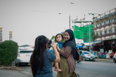Muslim mother and toddler taking photo at the street in thailand.
