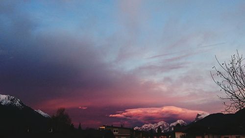 Silhouette houses against sky during sunset