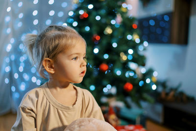 Close-up of cute girl playing with christmas tree