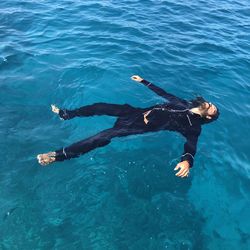 High angle view of man floating on sea