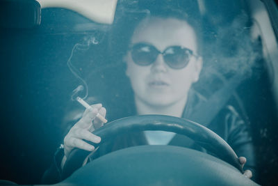 Portrait of young woman smoking cigarette