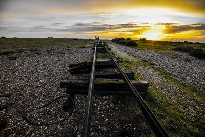 Railroad tracks against sky during sunset