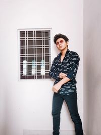 Portrait of young man looking away against wall