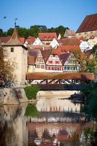 Houses by river and buildings against sky