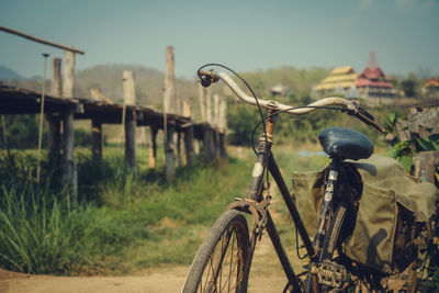 Close-up of bicycle on field against sky