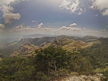 Scenic view of mountains against cloudy sky