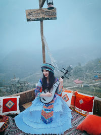 Portrait of woman with arms sign on mountain