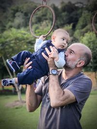 Father and son holding baby