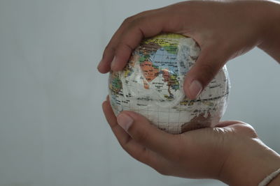 Close-up of person holding hands over white background