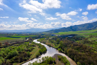 Scenic view of river amidst field against sky