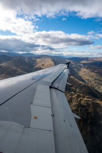 Airplane flying over landscape against sky