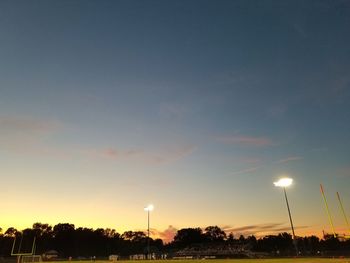 Low angle view of illuminated trees against sky during sunset