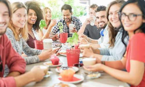 Happy friends having food at table