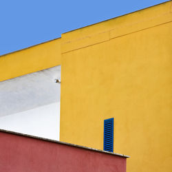 Low angle view of yellow building against sky