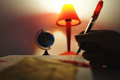 Close-up of hand holding illuminated lamp