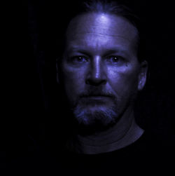 Portrait of young woman against black background