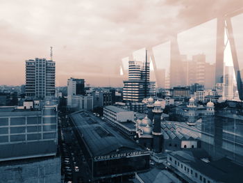 Buildings in city against cloudy sky