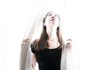 Portrait of woman standing against white background