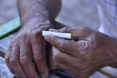 Close-up of hand holding cigarette