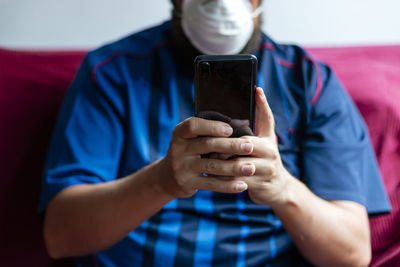 Close-up of a person using his smartphone in quarantine