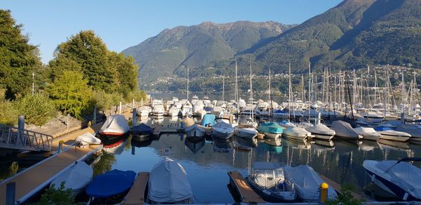 Sailboats moored in lake against mountains